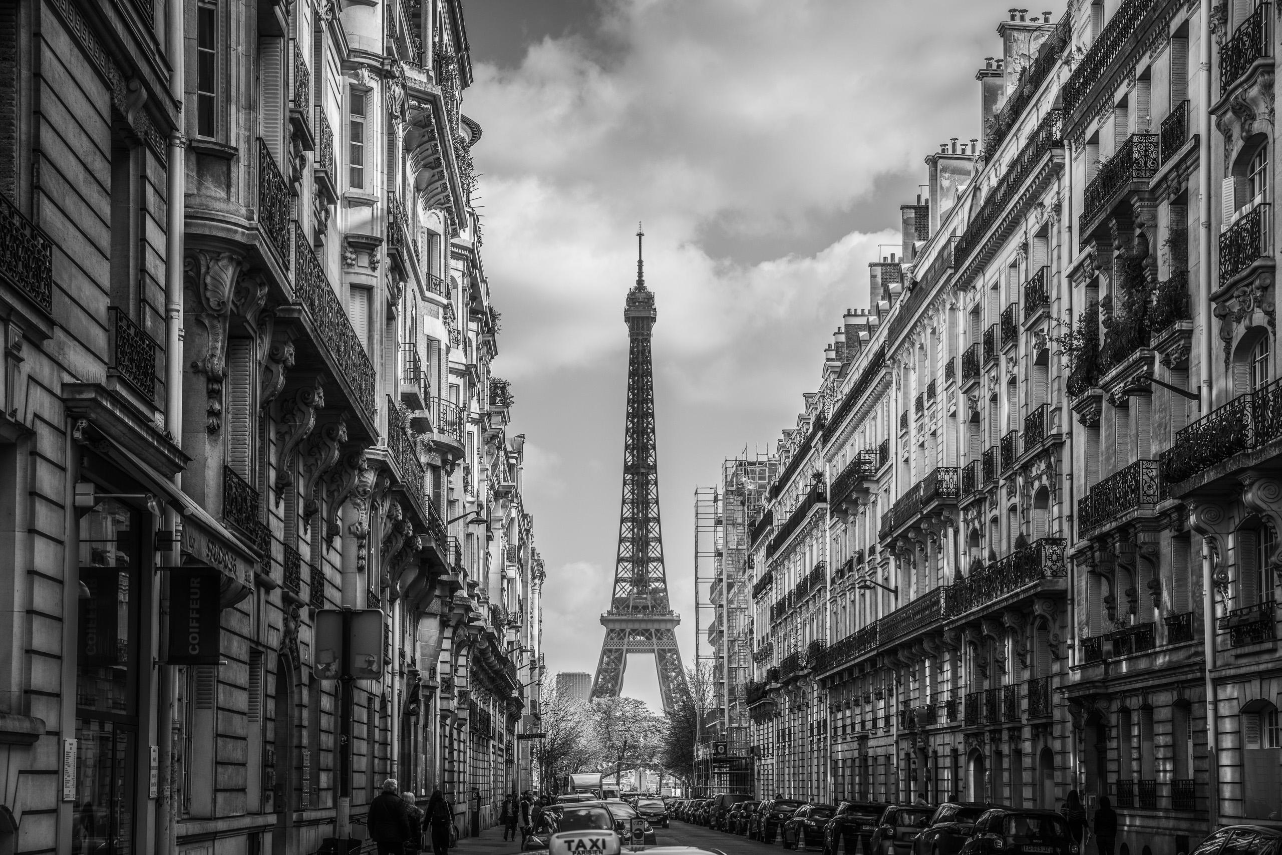Black and white photograph of the Eiffel Tower framed by Parisian buildings