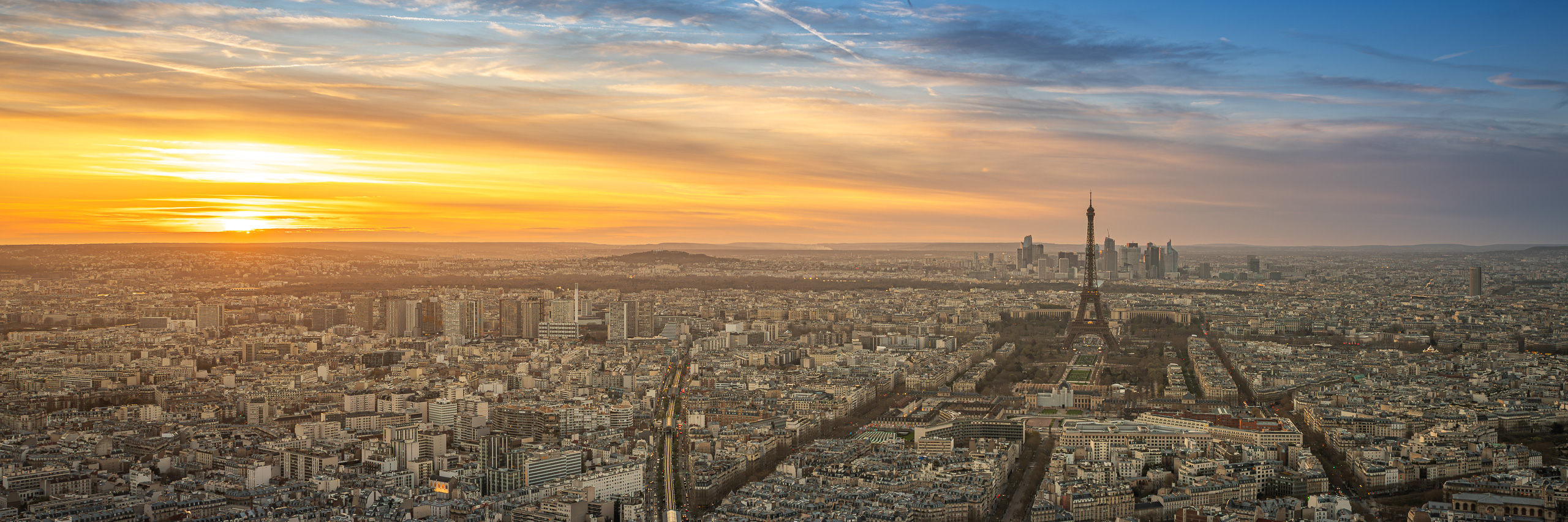 Panoramic sunset view of Paris with the Eiffel Tower rising above the city skyline