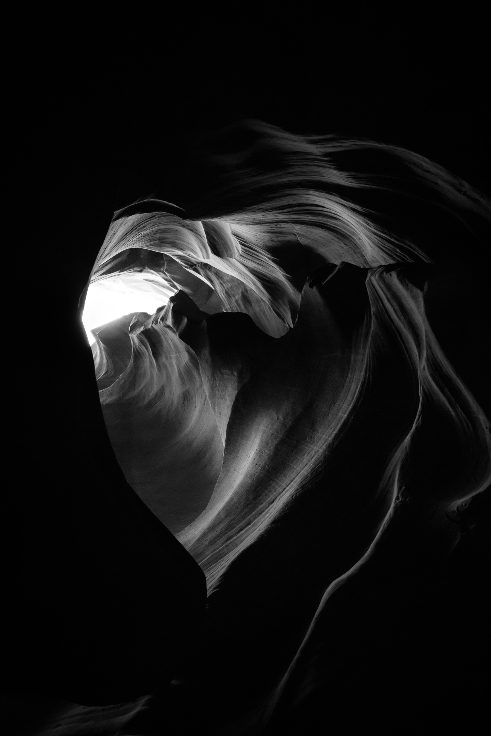Black and white heart-shaped sandstone formation inside Antelope Canyon with dramatic light and shadow