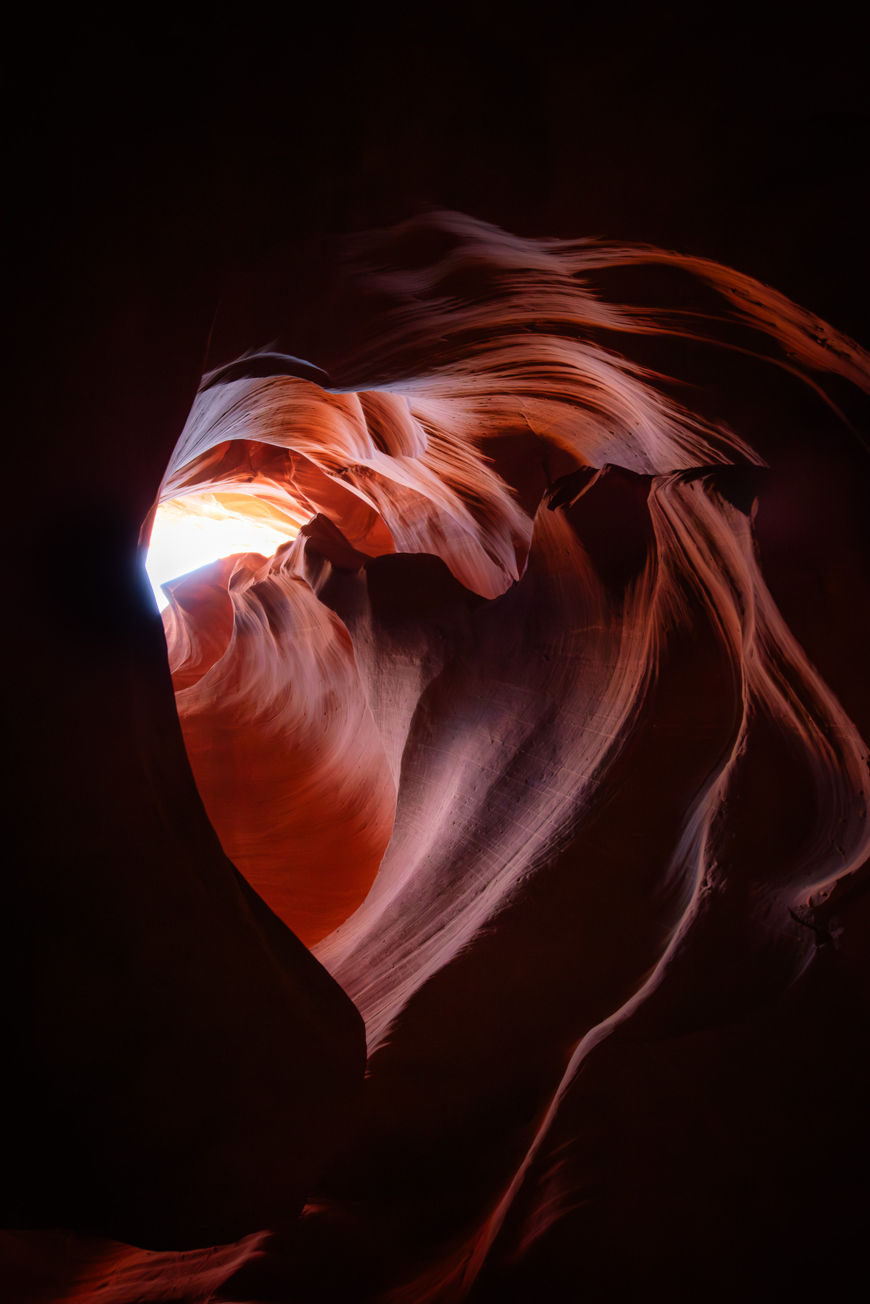 Heart-shaped sandstone formation glowing with warm light inside Antelope Canyon in Arizona