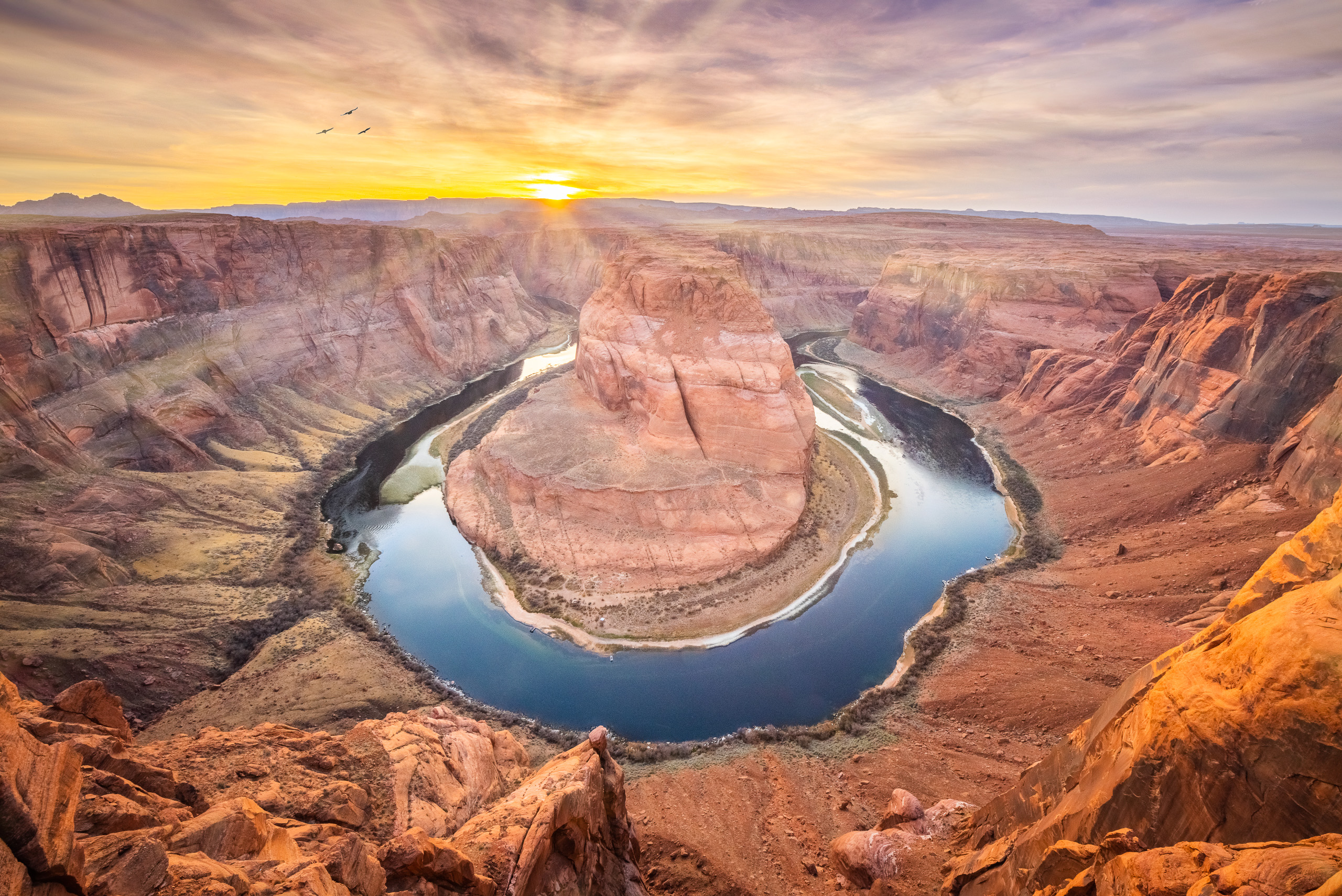 Sunset view of Horseshoe Bend with the Colorado River curving around red canyon cliffs in Arizona