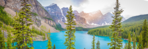 Panoramic view of Moraine Lake with turquoise water, pine trees, and Rocky Mountains in Banff National Park Canada