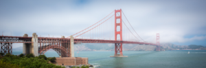 Panoramic photograph of the Golden Gate Bridge in San Francisco with fog over the bay and bridge towers