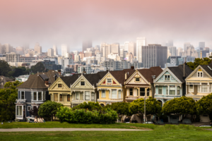 Color photograph of San Francisco Painted Ladies Victorian homes with city skyline in the background