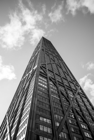 Black and white vertical photograph looking up at the John Hancock Center skyscraper in Chicago