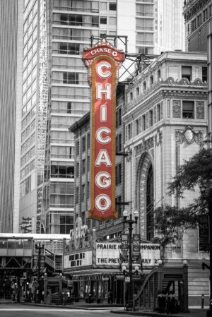 Vertical black and white photograph of the Chicago Theatre with selective color marquee sign in downtown Chicago