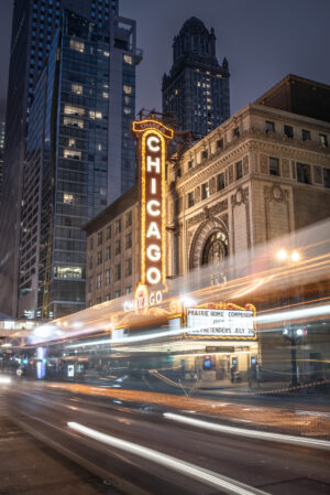 Vertical photograph of the Chicago Theatre marquee at night with city light trails