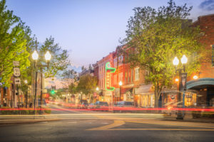 Long exposure of the Gray's on Main neon sign at dusk in historic downtown Franklin, Tennessee, with colorful light trails from passing traffic.