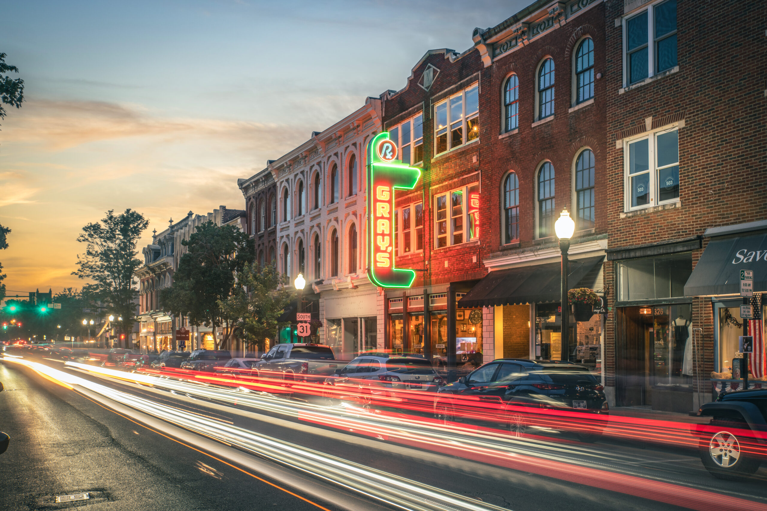 Downtown Franklin, Tennessee at sunset featuring Gray's on Main with colorful neon signage and long-exposure light trails along Main Street.