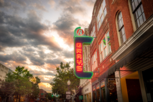 Gray's on Main neon sign glowing at sunset in historic downtown Franklin, Tennessee, framed by dramatic clouds and classic brick storefronts.