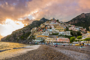 Panoramic photograph of Positano beach at sunset on the Amalfi Coast Italy with colorful hillside village