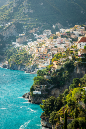 Vertical photograph of Positano on the Amalfi Coast Italy with colorful hillside homes above turquoise sea