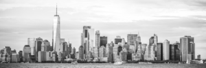 Black and white panoramic view of the New York City skyline with One World Trade Center across the water