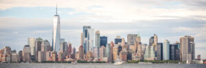 Lower Manhattan skyline panorama with One World Trade Center in color viewed across New York Harbor