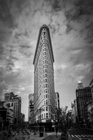 Flatiron Building in black and white rising above Manhattan streets in New York City