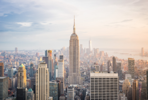 Empire State Building above the New York City skyline at sunset with warm golden light