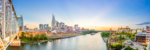 Panoramic sunset view of Nashville Tennessee skyline and Cumberland River with bridge and stadium
