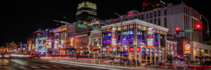 Panoramic night scene of Broadway in downtown Nashville Tennessee with neon bars and traffic light trails