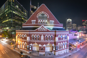 Ryman Auditorium in Nashville Tennessee illuminated at night with downtown skyline lights
