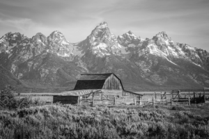 Black and white photograph of Mormon Row barn with Grand Teton mountains in Wyoming