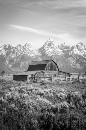Black and white photograph of Mormon Row barn with Grand Teton mountains in Wyoming