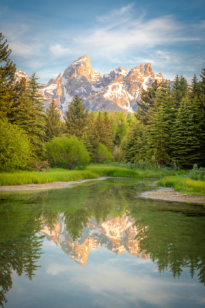Grand Teton mountains reflected in calm water at Schwabacher Landing in Wyoming