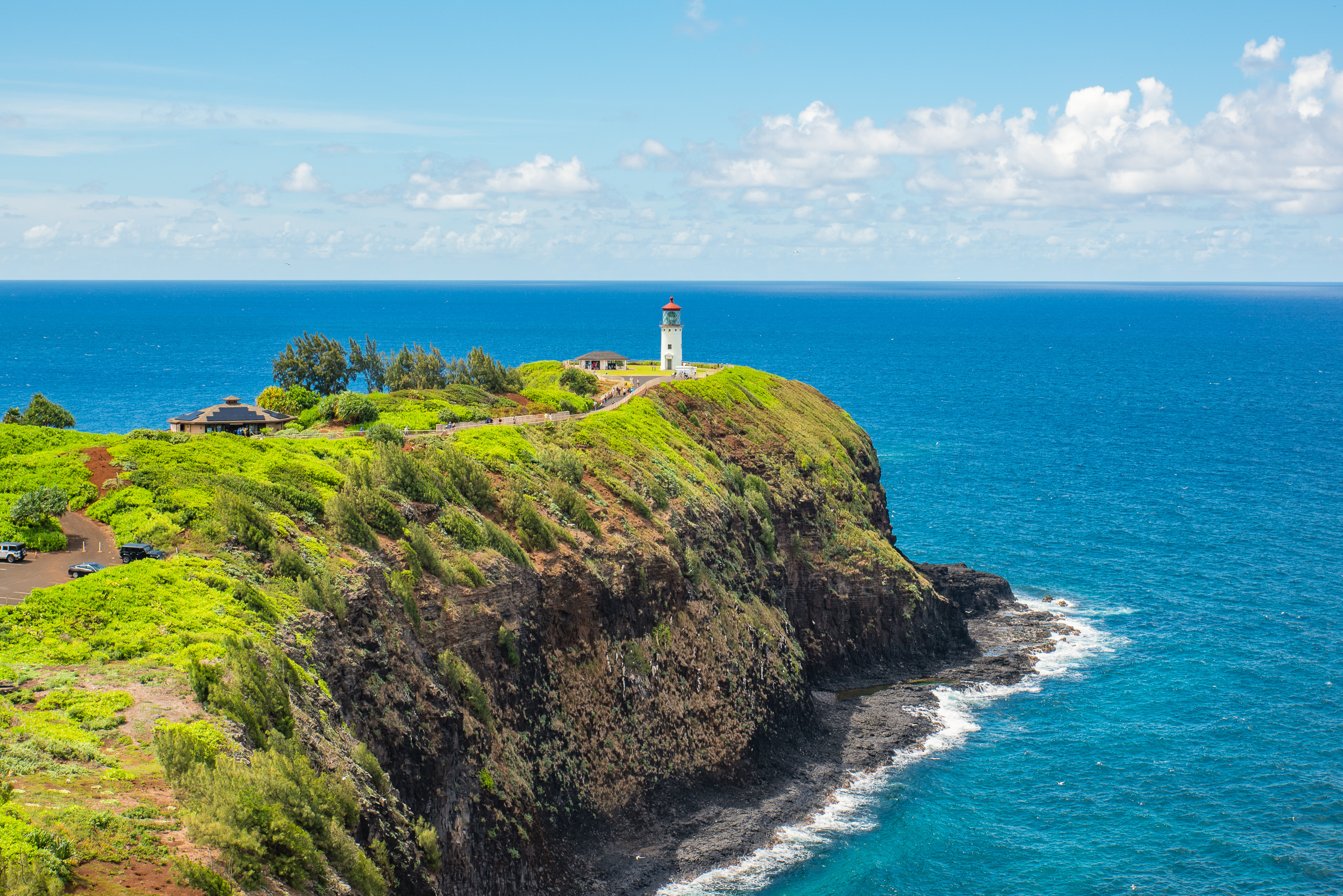 Kilauea Lighthouse on dramatic ocean cliffs in Kauai Hawaii with turquoise Pacific waters and blue sky