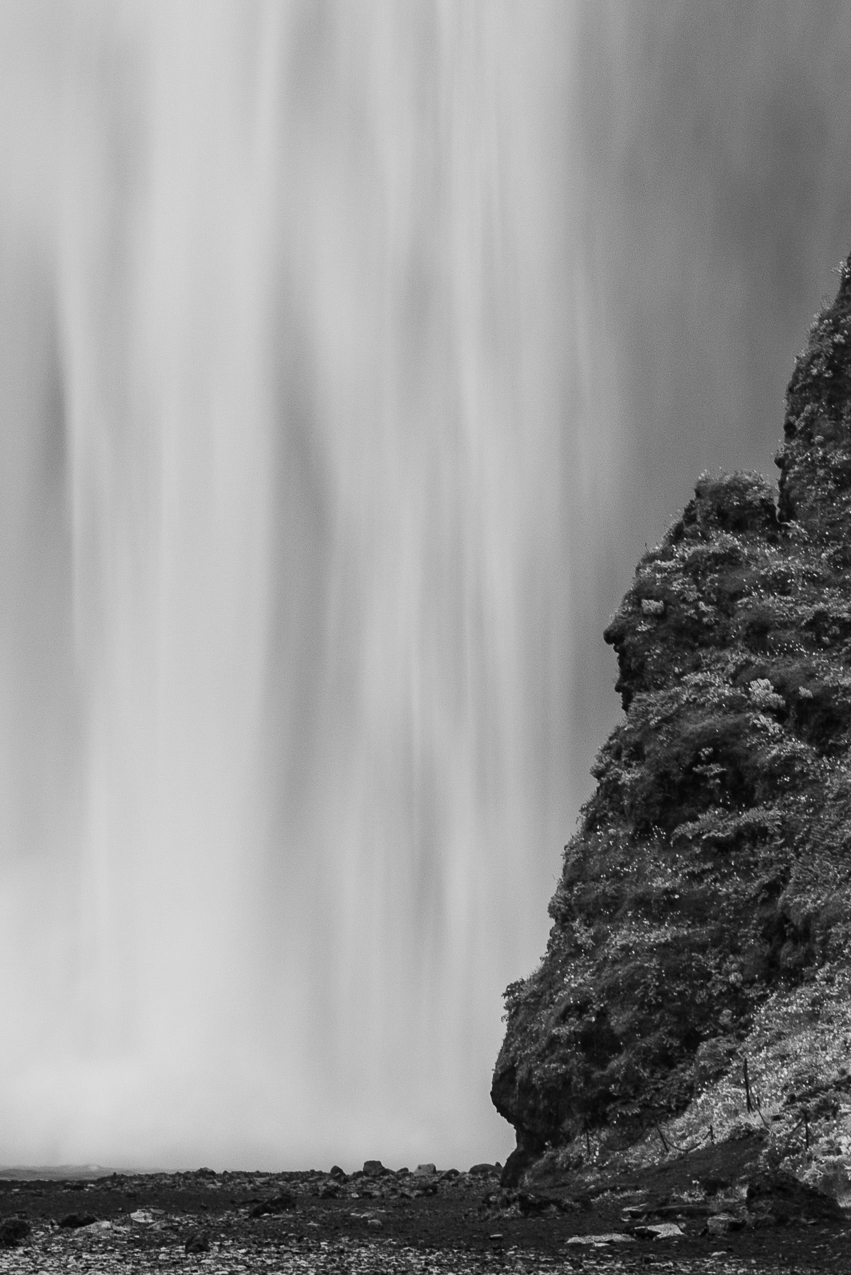 Black and white close view of Skogafoss waterfall with rocky cliff in Iceland