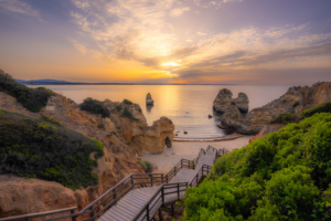Sunrise over Camilo Beach cliffs and sea stacks in Algarve Portugal