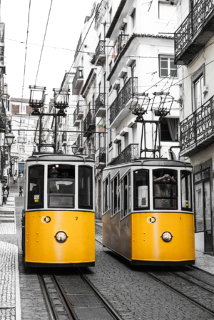 Yellow Lisbon funicular trams on steep street with black and white city background