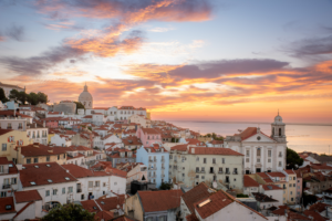 Lisbon sunrise over the Alfama district with colorful rooftops and the Tagus River in Portugal