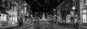 Panoramic black and white snowy Main Street in downtown Franklin Tennessee with Christmas tree at night