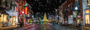 Panoramic snowy Main Street in downtown Franklin Tennessee with Christmas tree and holiday lights at night