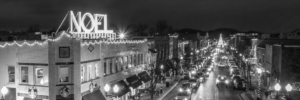 Panoramic black and white Noel sign above downtown Franklin Tennessee Christmas lights at night