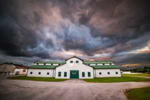 Historic barn at Harlinsdale Farm in Franklin Tennessee beneath dramatic storm clouds