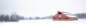 Red barn in snowy field near Franklin Tennessee during winter panorama landscape