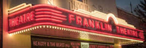 Historic Franklin Theatre marquee glowing at night in downtown Franklin Tennessee panorama