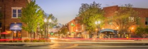 Panoramic long exposure of downtown Franklin, Tennessee at dusk, featuring the iconic Gray's on Main neon sign and colorful light trails along historic Main Street.