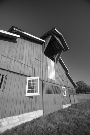 Black and white photograph of the historic Hillsboro Road barn with an American flag in Franklin, Tennessee