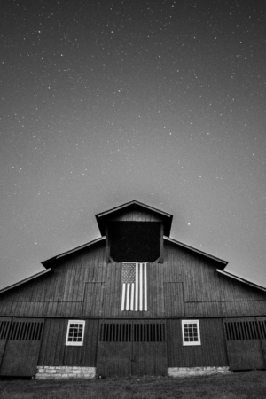Black and white photograph of the historic Hillsboro Road barn beneath a star-filled sky in Franklin, Tennessee