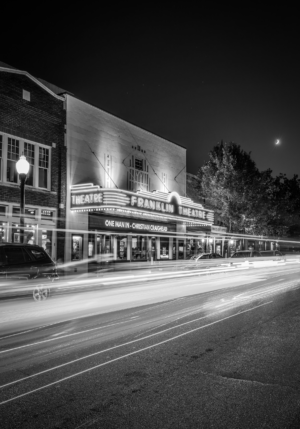 Vertical black and white long exposure photograph of the historic Franklin Theatre at night in downtown Franklin, Tennessee