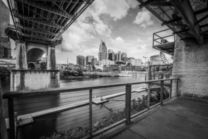 Black and white Nashville Tennessee skyline viewed from beneath the John Seigenthaler Pedestrian Bridge along the Cumberland River