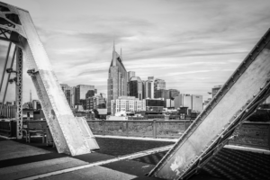 Black and white Nashville Tennessee skyline framed by steel beams of the John Seigenthaler Pedestrian Bridge