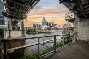 Nashville Tennessee skyline at sunset viewed from beneath the historic John Seigenthaler Pedestrian Bridge along the Cumberland River